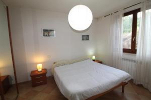 ein Schlafzimmer mit einem Bett und zwei Kerzen auf Tischen in der Unterkunft Bellavista apartment 20 minutes from sea/beaches in Giuncarico