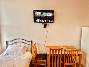 a bedroom with a bed and a table and a tv on the wall at Entire Flat With View to River Yare, H 1 in Great Yarmouth