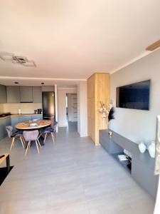 a kitchen and living room with a table and chairs at Apartament Luxusowe Karkonosze in Jelenia Góra