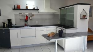 uma cozinha com armários brancos e uma bancada em Villa d'Arçay - ADRIAE Home em LʼAiguillon-sur-Mer