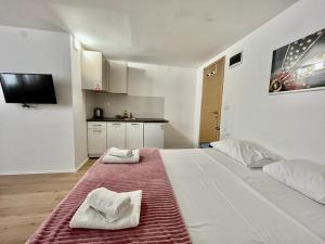 a bedroom with a bed with two towels on it at Apartmani ROZA in Pula