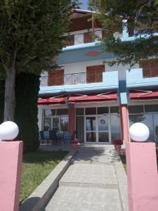 a building with a walkway in front of it at Hotel Limni in Agios Panteleimon