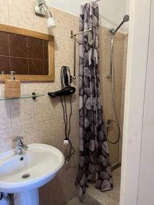 a bathroom with a shower curtain and a sink at Apartamentai Palangos Centre in Palanga +25 photos