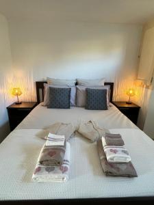 1 cama con 2 toallas y 2 lámparas en Gîte l’Inattendu en Vachères