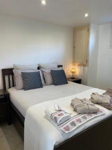 a bedroom with a large white bed with towels on it at Gîte l’Inattendu in Vachères