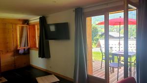 a room with a balcony with a table and an umbrella at Le Grossglockner in Les Contamines-Montjoie