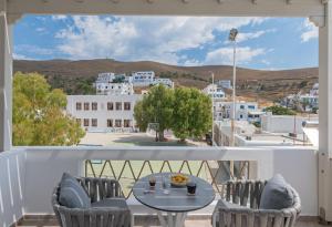 a balcony with a table and chairs and a view of a town at Viva Mare Studios in Astypalaia Town