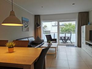 cocina y sala de estar con mesa y sillas en Neymeer, en Norderney