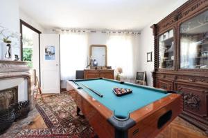 um quarto com uma mesa de bilhar e uma lareira em Dans maison de charme, bel appartement privatif em Saint-Laurent-de-Brévedent