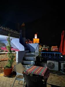 una mesa y sillas en un balcón con vistas en Riad Nerja, en Chefchaouen