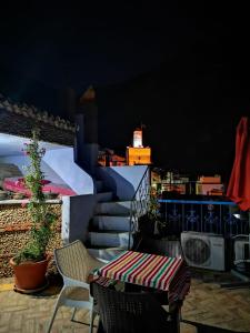 einen Tisch und Stühle auf einem Balkon mit Aussicht in der Unterkunft Riad Nerja in Chefchaouen