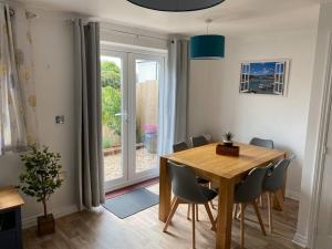 a dining room with a table and chairs and a window at Stylish 3 bed home with allocated parking for 2 in Liskeard