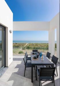 a dining room with a table and chairs and the ocean at Oliva Suites in Oliva