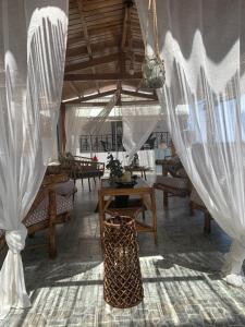 a room with white curtains and tables and chairs at Argo in Skala