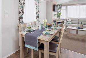 uma mesa de jantar e cadeiras numa sala de estar em St Andrews Holiday Home Walk to the Old Course em St. Andrews