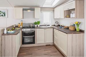 uma cozinha com armários brancos e um forno com placa de fogão em St Andrews Holiday Home Walk to the Old Course em St. Andrews