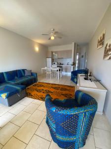 uma sala de estar com sofás azuis e uma mesa em Sea view Ka Paola, Praia Cabral, Boa Vista, FREE WI-FI em Sal Rei
