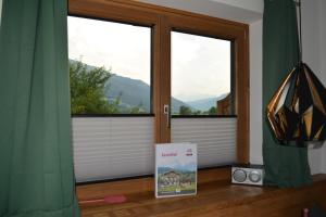 een kamer met twee ramen en een boek op de vloer bij Ramseiderhof in Saalfelden am Steinernen Meer