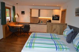 a bedroom with a bed and a kitchen with a table at Ramseiderhof in Saalfelden am Steinernen Meer