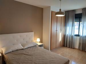 ein Schlafzimmer mit einem großen Bett und einem Fenster in der Unterkunft Mi Apartamento en el Delta del Ebro in Deltebre