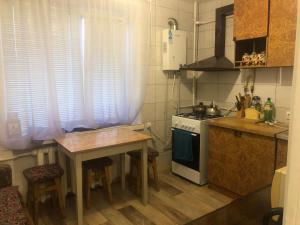 a small kitchen with a table and a stove at Квартира Пентагон in Korostenʼ