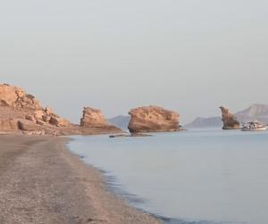 a beach with some rocks in the water at Traditional art apartment 3 in Akoumia