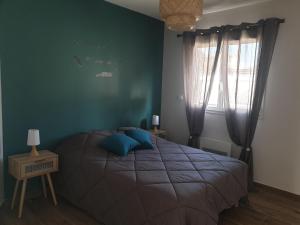 ein Schlafzimmer mit einem Bett und einer grünen Wand in der Unterkunft Gîtes des Clapas Lisa, villa**** piscine privée in Balazuc
