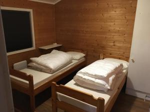 two beds in a room with a window at Hafjell/Lillehammer Sorlia 3 bedroom Cabin in Hafjell