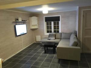 ein Wohnzimmer mit einem Sofa und einem Flachbild-TV in der Unterkunft Hafjell/Lillehammer Sorlia 3 bedroom Cabin in Hafjell