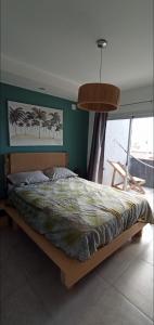 1 dormitorio con 1 cama grande y pared verde en Playa Union temporario apart en Playa Unión