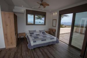a bedroom with a bed and a balcony at Panorama Studios in Kefalos
