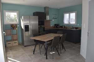 a kitchen with a wooden table and a refrigerator at Gîtes des Clapas Lisa, villa**** piscine privée in Balazuc