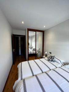 a large bedroom with two beds and a mirror at Gijón del alma in Gijón
