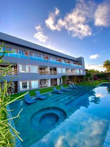 a resort with a swimming pool and lounge chairs at Villa Pantai Boutique Hotel Maragogi in Maragogi