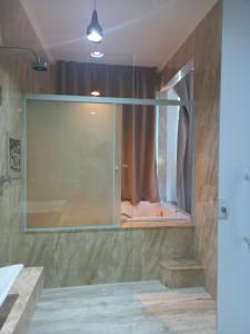 La salle de bains est pourvue d'une douche et d'une grande fenêtre en verre. dans l'établissement Pousada Kaetê, à Parati
