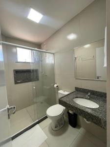 a bathroom with a shower and a toilet and a sink at Pousada e Restaurante Altas Horas Beach in Itapipoca