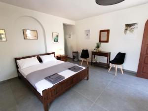 sypialnia z łóżkiem i 2 krzesłami w obiekcie Casadelvilla private apartment PortoCheli-Kosta w mieście Porto Heli