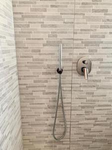 una ducha con una manguera pegada a una pared de ladrillo en MacchiabelliHome Centro Recco, en Recco