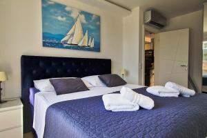 a bedroom with a large bed with towels on it at Aquamarine Deluxe Apartment in Dubrovnik