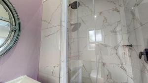 a bathroom with a shower with a glass door at Caribbean Estate Supreme by Top Destinations Rentals in Port Edward