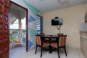 ein Esszimmer mit einem Tisch, Stühlen und einem TV in der Unterkunft Red Sunset Beach Club in Boqueron