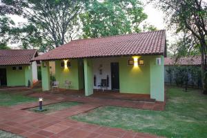 uma pequena casa verde com um telhado vermelho em Aguativa Golf Resort em Cornélio Procópio