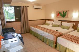 コルネーリオ・プロコーピオにあるAguativa Golf Resortのベッド2台とデスクが備わるホテルルームです。