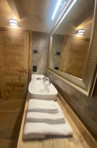 uma casa de banho com lavatório, espelho e toalhas em Il Falco Affittacamere em Gallio