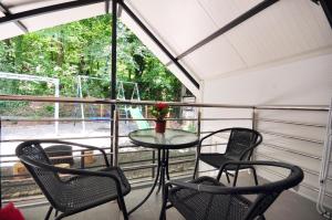 a table and chairs on a screened porch with a table and two chairs at Stil Park Apartmani in Vrnjačka Banja