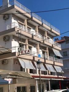 un edificio blanco con balcones blancos y luz de la calle en Vila Eva, en Paralia Katerinis
