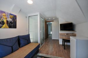 a living room with a couch and a flat screen tv at Stil Park Apartmani in Vrnjačka Banja