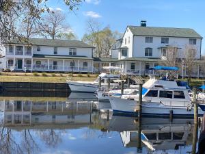 three boats docked in a marina in front of houses at The Cypress Inn in Conway