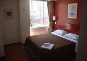 Una habitación de hotel con una cama con una toalla. en Filatelia Suites & Travel, en Quito