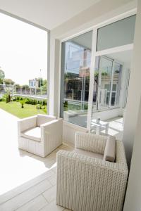 a living room with two chairs and a large window at Luxury House in Villapiana